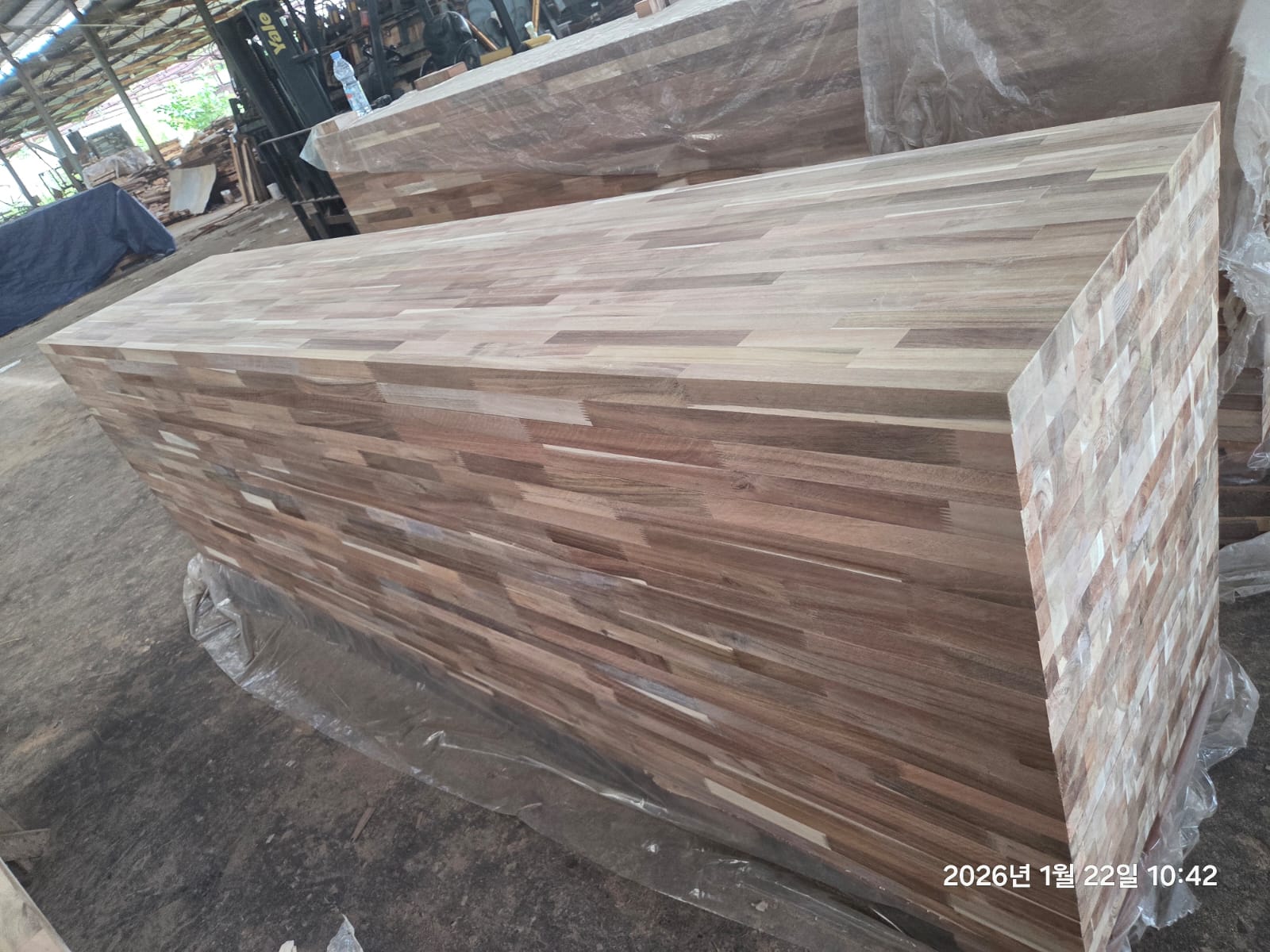Large stacks of unfinished butcher block panels prepared in the workshop